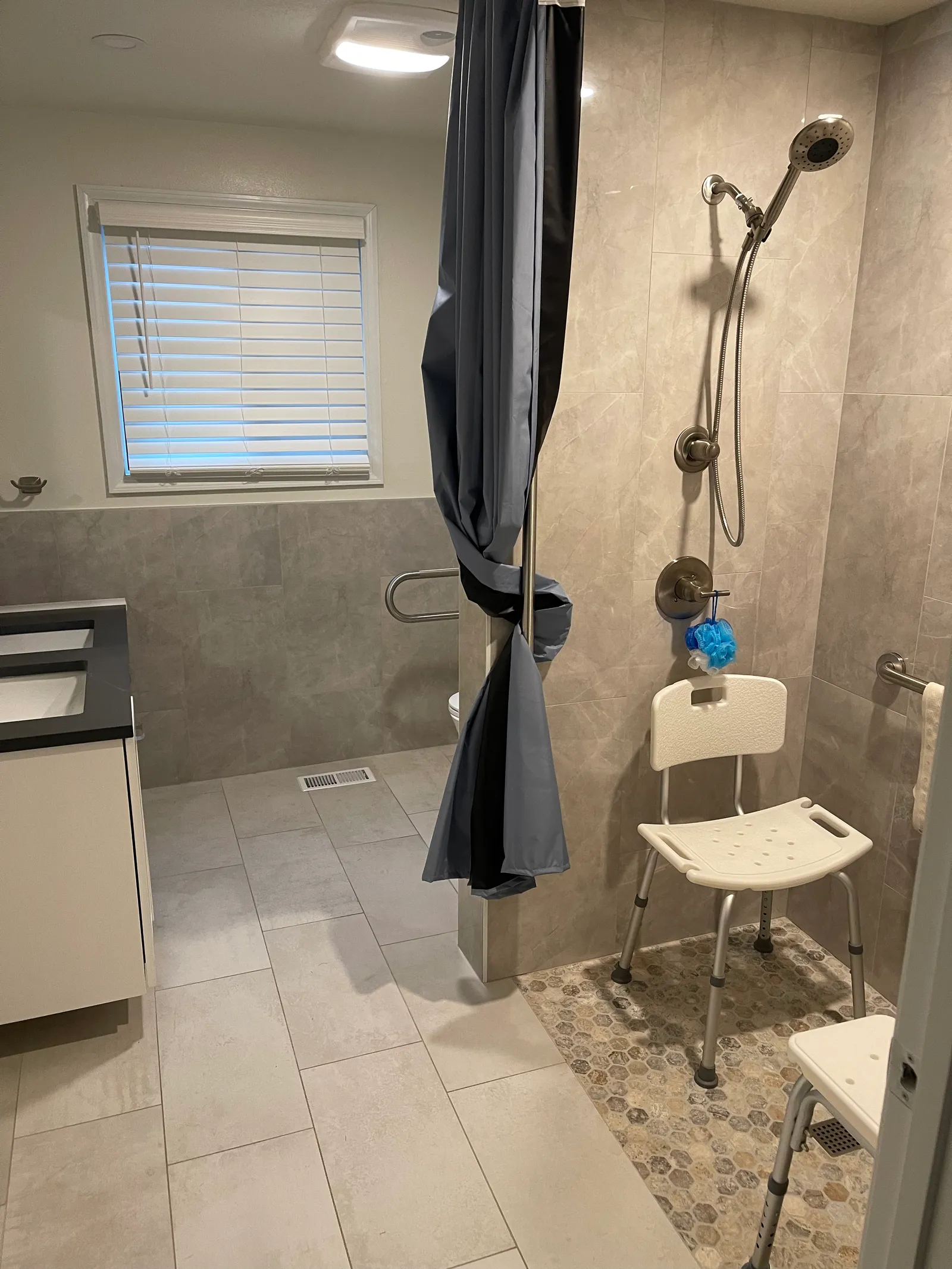 Walk-in shower with grab bars and shower seat at Blue Mountain Residential Care Home in Oregon City