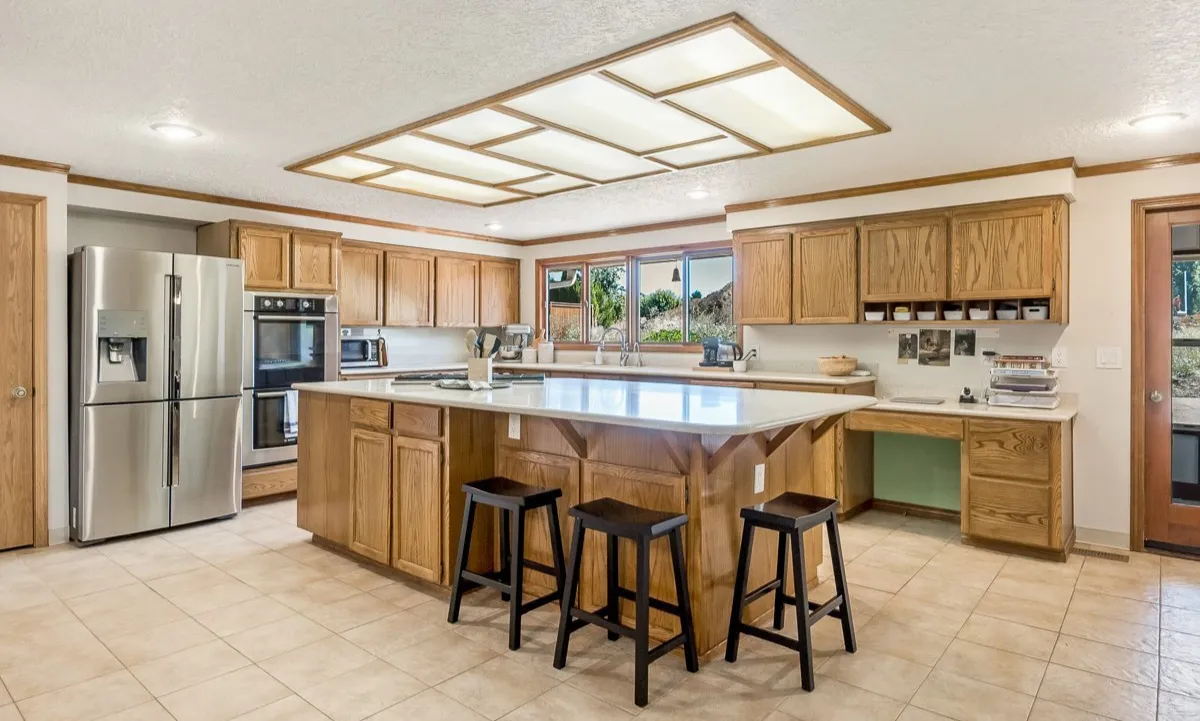 Kitchen at Blue Mountain Residential Care Home in Oregon City with island, oak cabinets, and stainless steel appliances